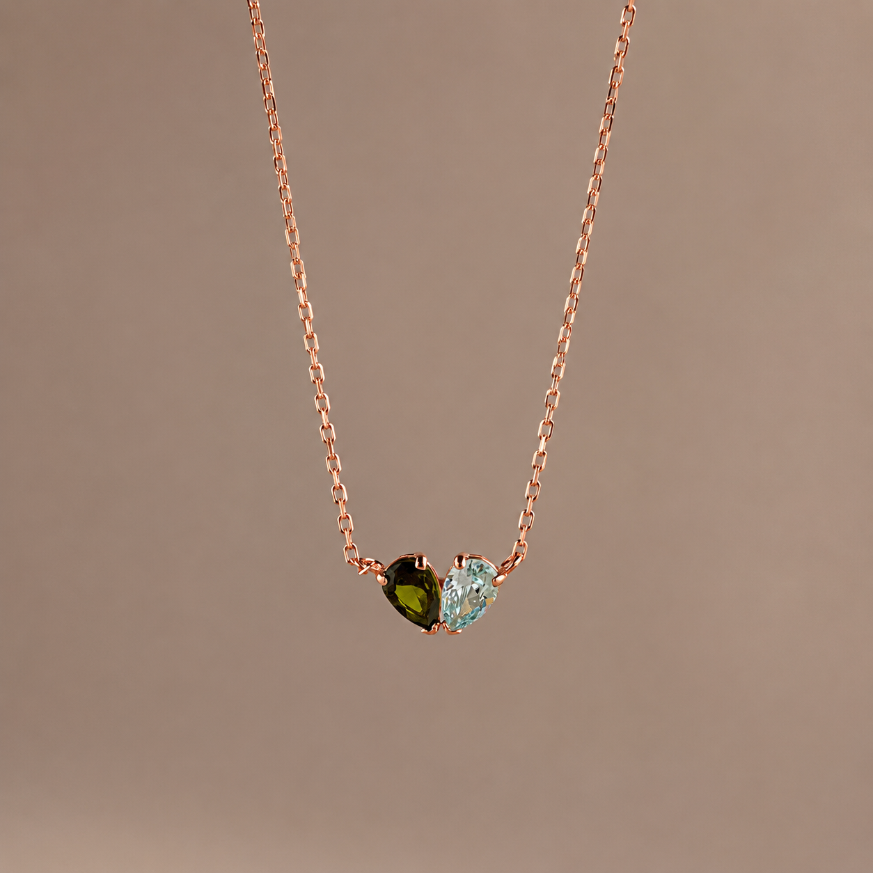 Necklace with three gemstones on a brown background